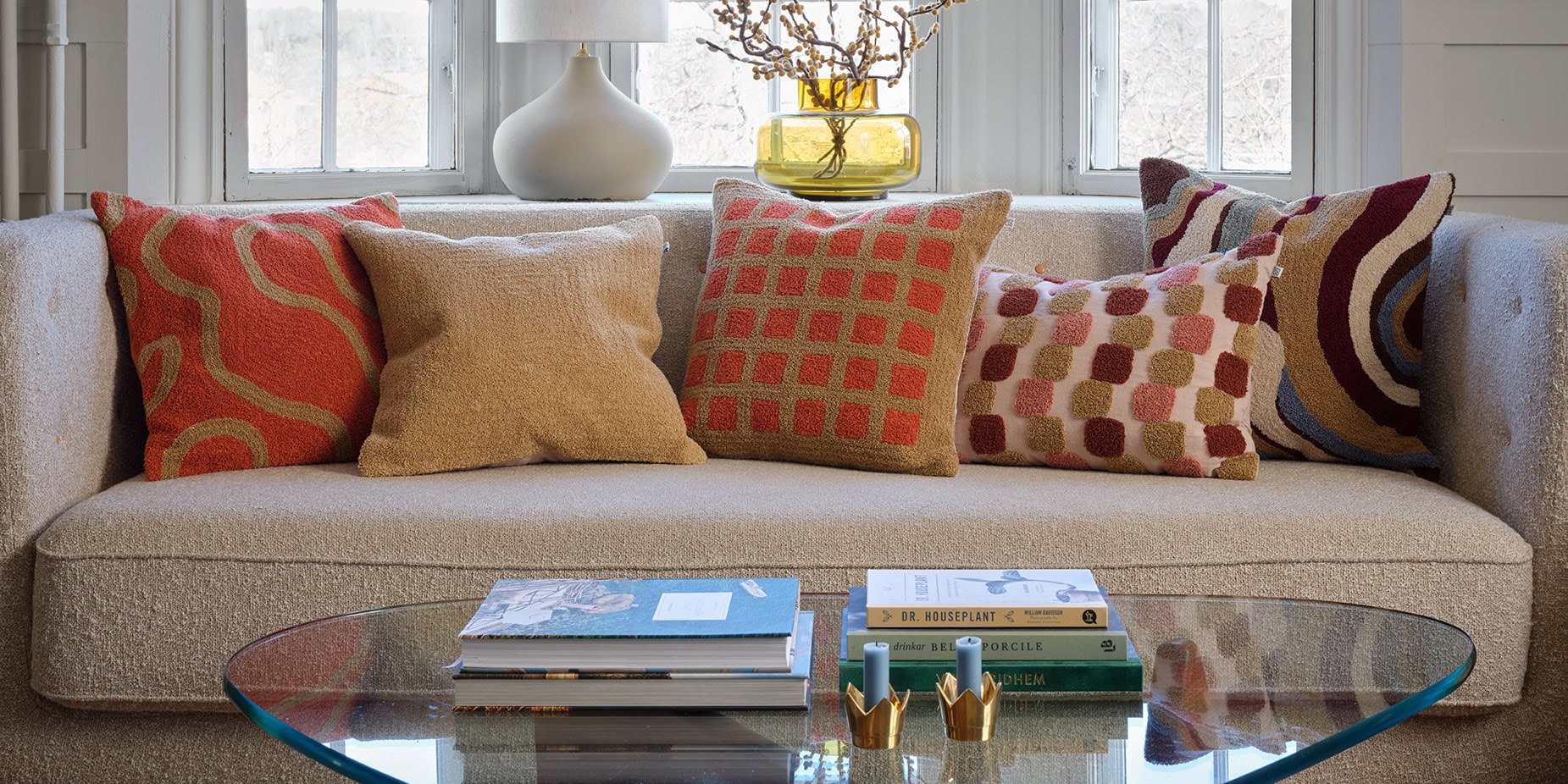 Orange, tan, rust, patterned sofa cushions in living room setting