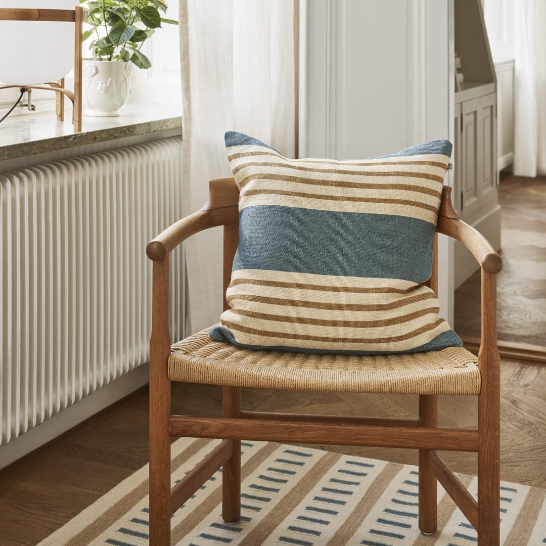 Randigt kuddfodral i blått och beige linne stylat i skandinavisk inredning