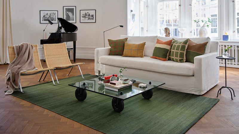 orange, beige och roströda mönstrade prydnadskuddar i bouclé på en beige soffa